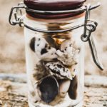 seashells in glass bottle sitting on wood